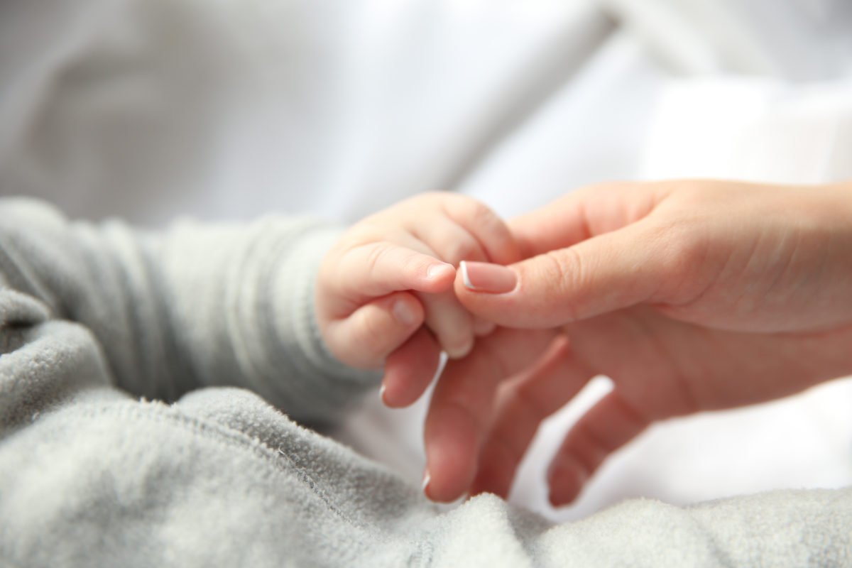 Mutter hält die Hand ihres Babys