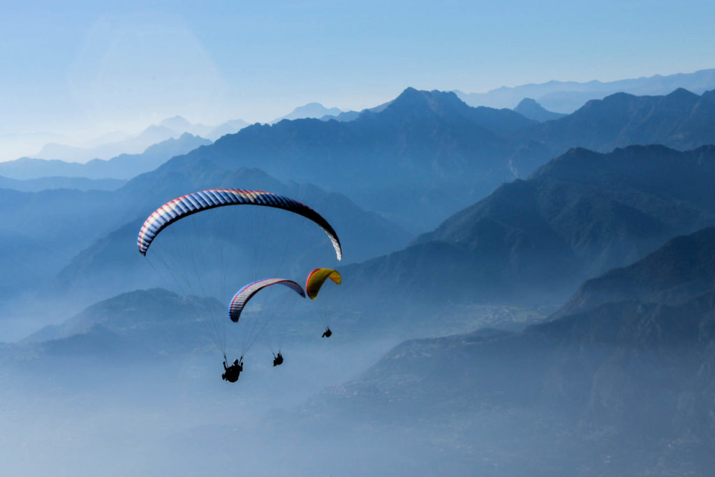 Drei Paraglider in der Bergen